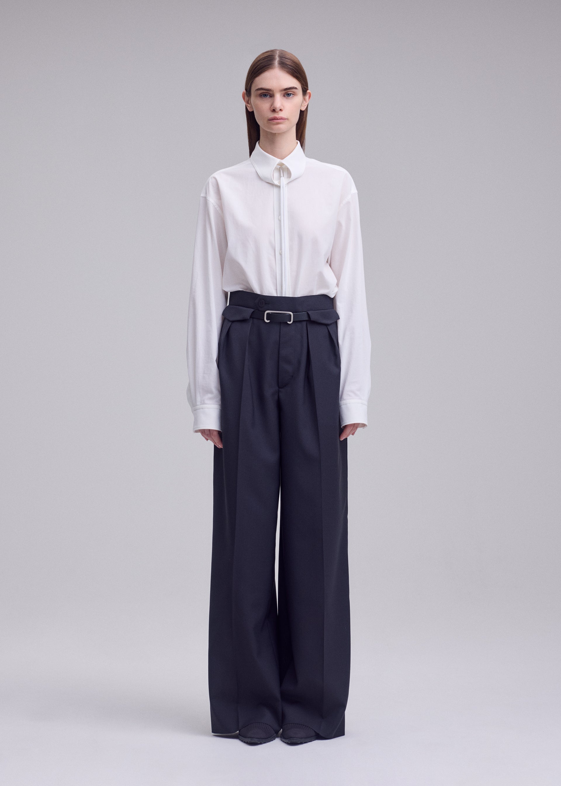 A model wears the ISSEY MIYAKE HONEST ENSEMBLE honest-ensemble-wide-leg-trousers-black.