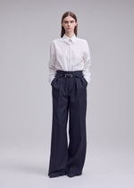 A model wears the ISSEY MIYAKE HONEST ENSEMBLE honest-ensemble-wide-leg-trousers-black.
