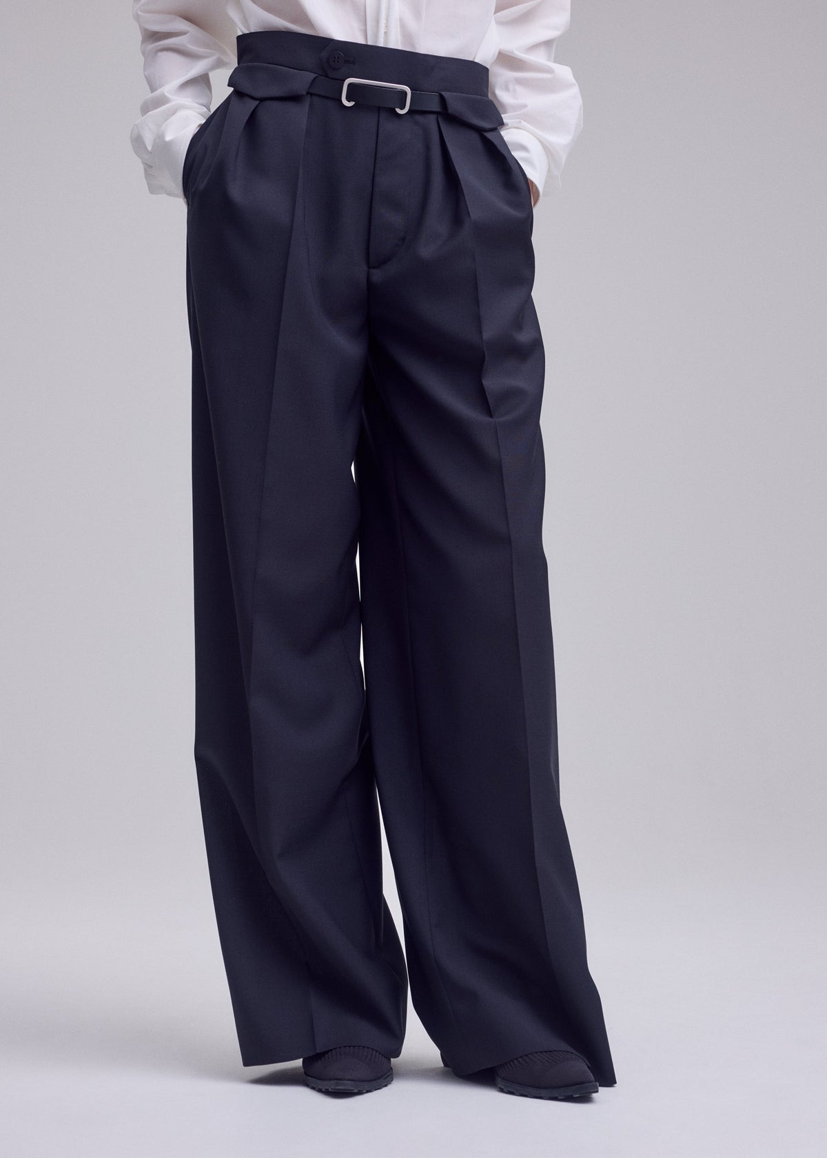 A model wears the ISSEY MIYAKE HONEST ENSEMBLE honest-ensemble-wide-leg-trousers-grey.
