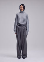 A model wears the ISSEY MIYAKE LUSTROUS WOOL PANTS lustrous-wool-pants-trousers-grey.