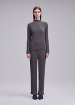 A model wears the ISSEY MIYAKE HATCHING PLEATS hatching-pleats-classic-cut-trousers-grey.