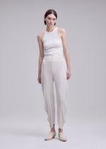 A model wears the ISSEY MIYAKE LEAF PLEATS leaf-pleats-trousers-dark-navy.