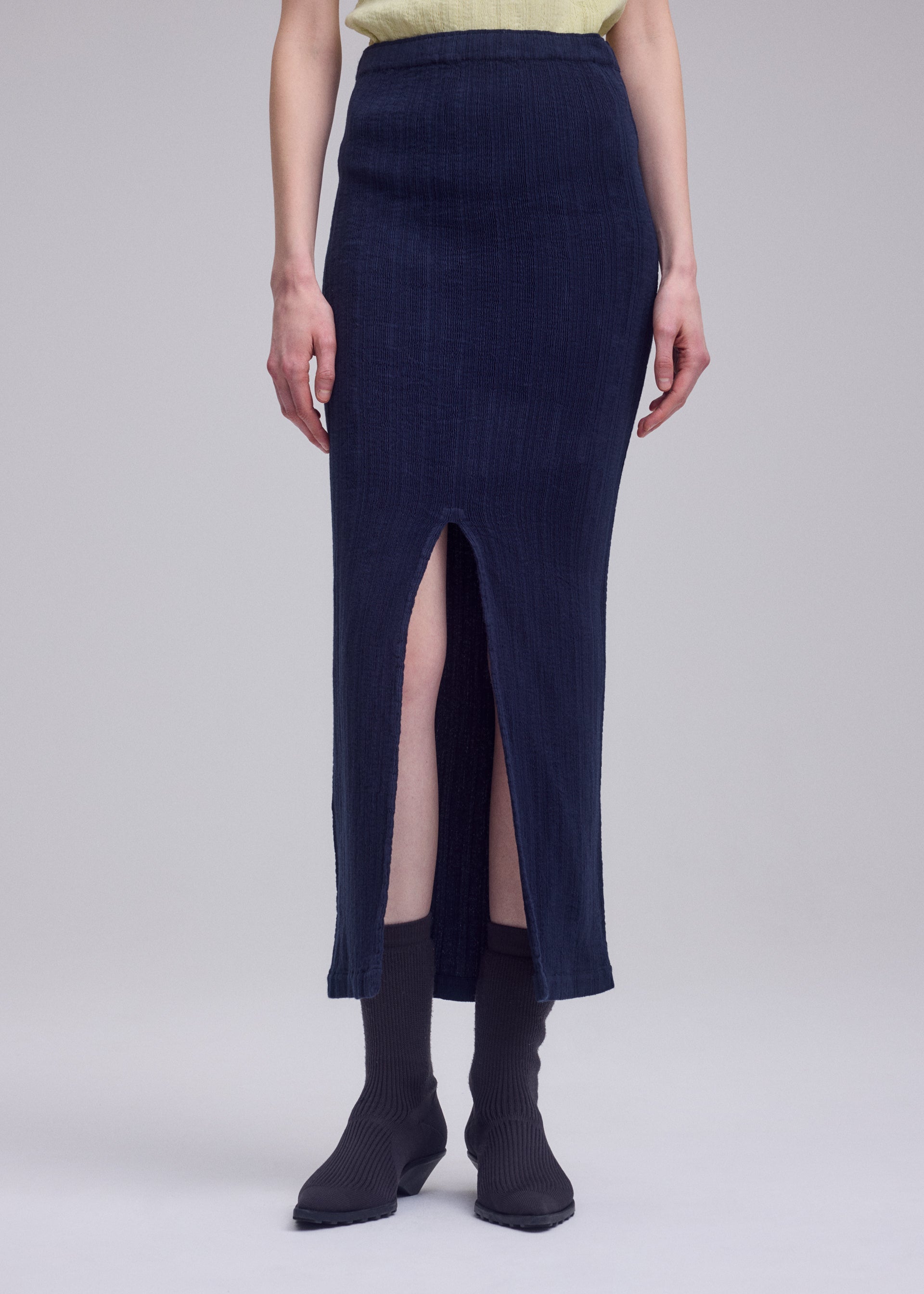 A model wears the ISSEY MIYAKE RILL rill-skirt-green.