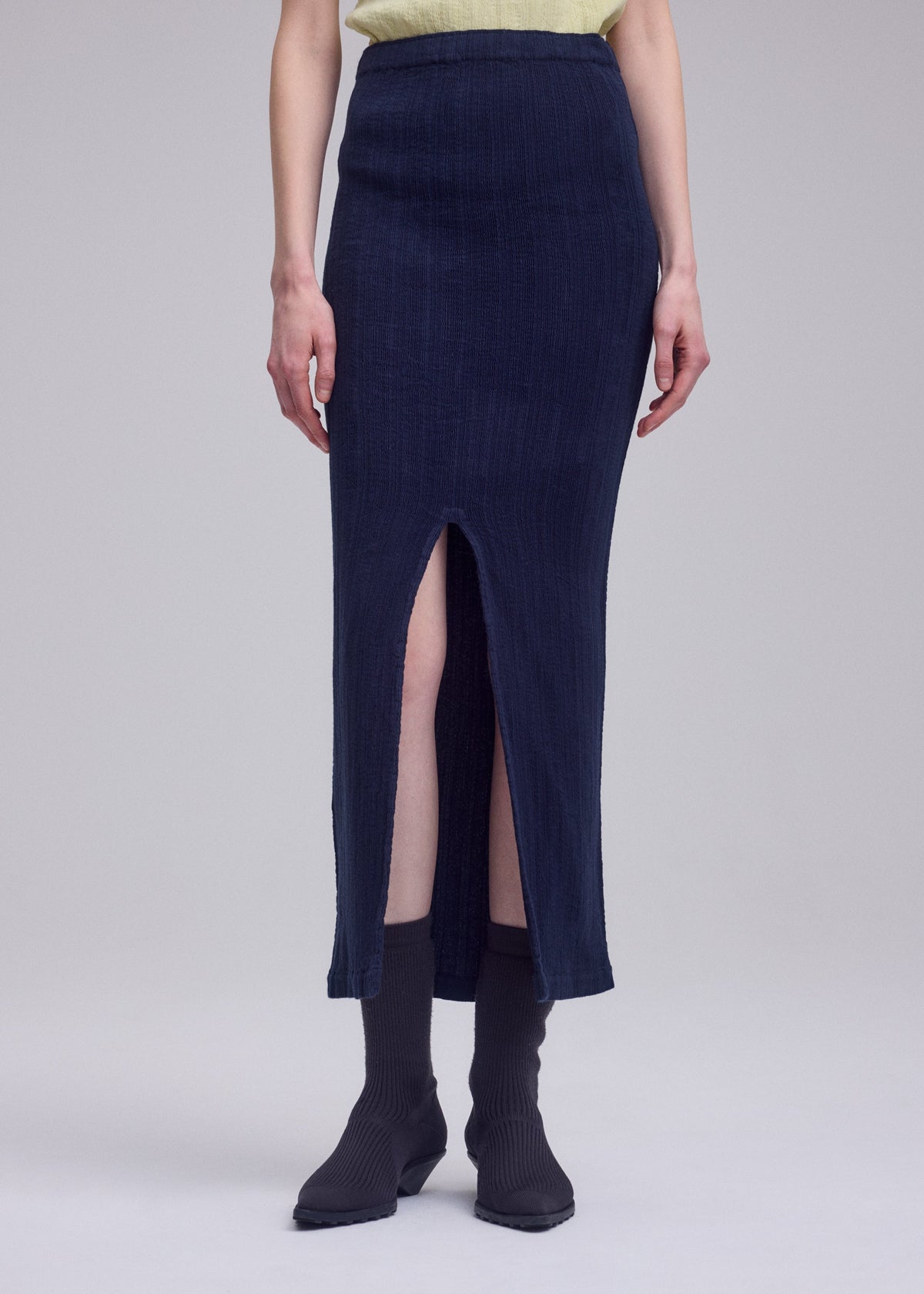 A model wears the ISSEY MIYAKE RILL rill-skirt-off-white.