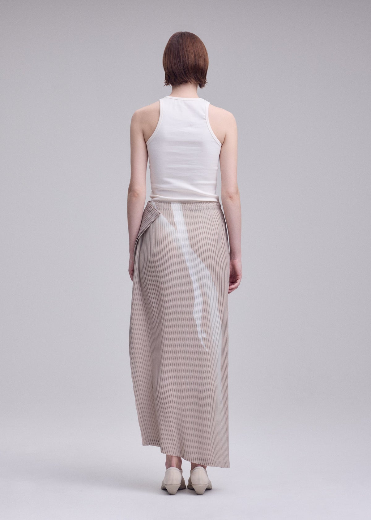 A model wears the ISSEY MIYAKE HANDS OF LOVER PLEATS hands-of-lover-pleats-skirt-black-hued.