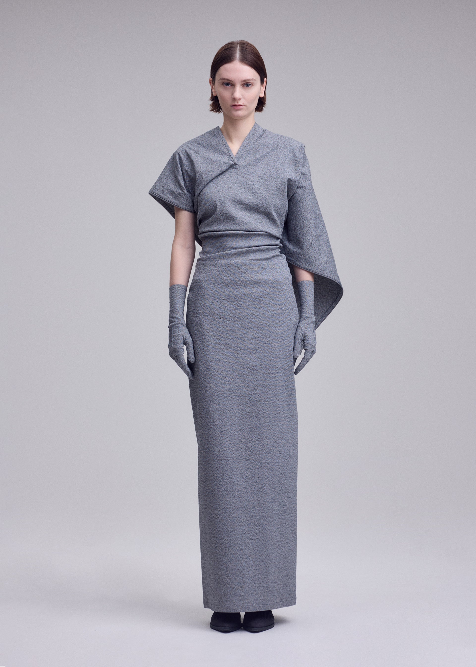 A model wears the ISSEY MIYAKE ALLOW dress.