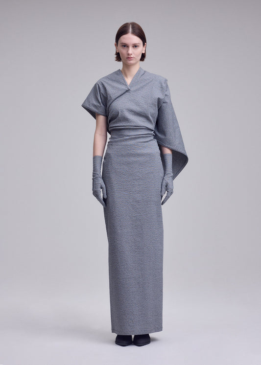 A model wears the ISSEY MIYAKE ALLOW dress.