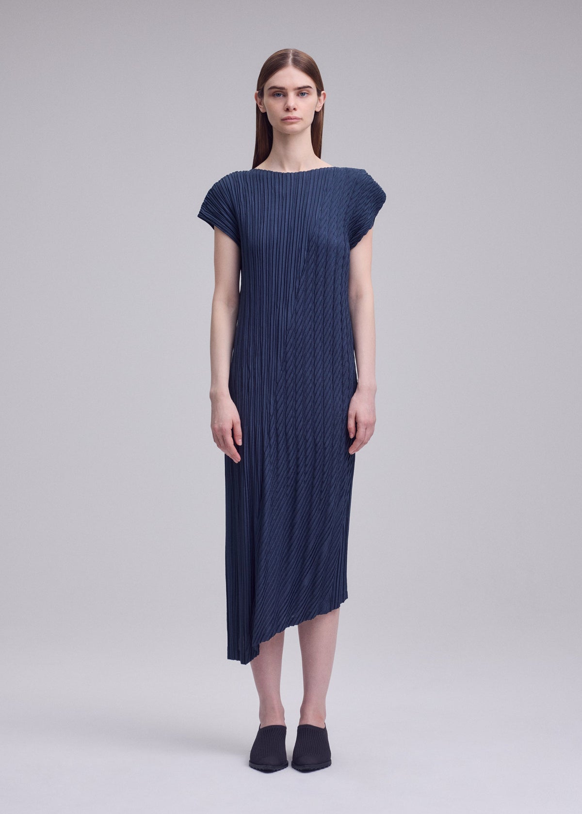 A model wears the ISSEY MIYAKE UNFURLING PLEATS dress.