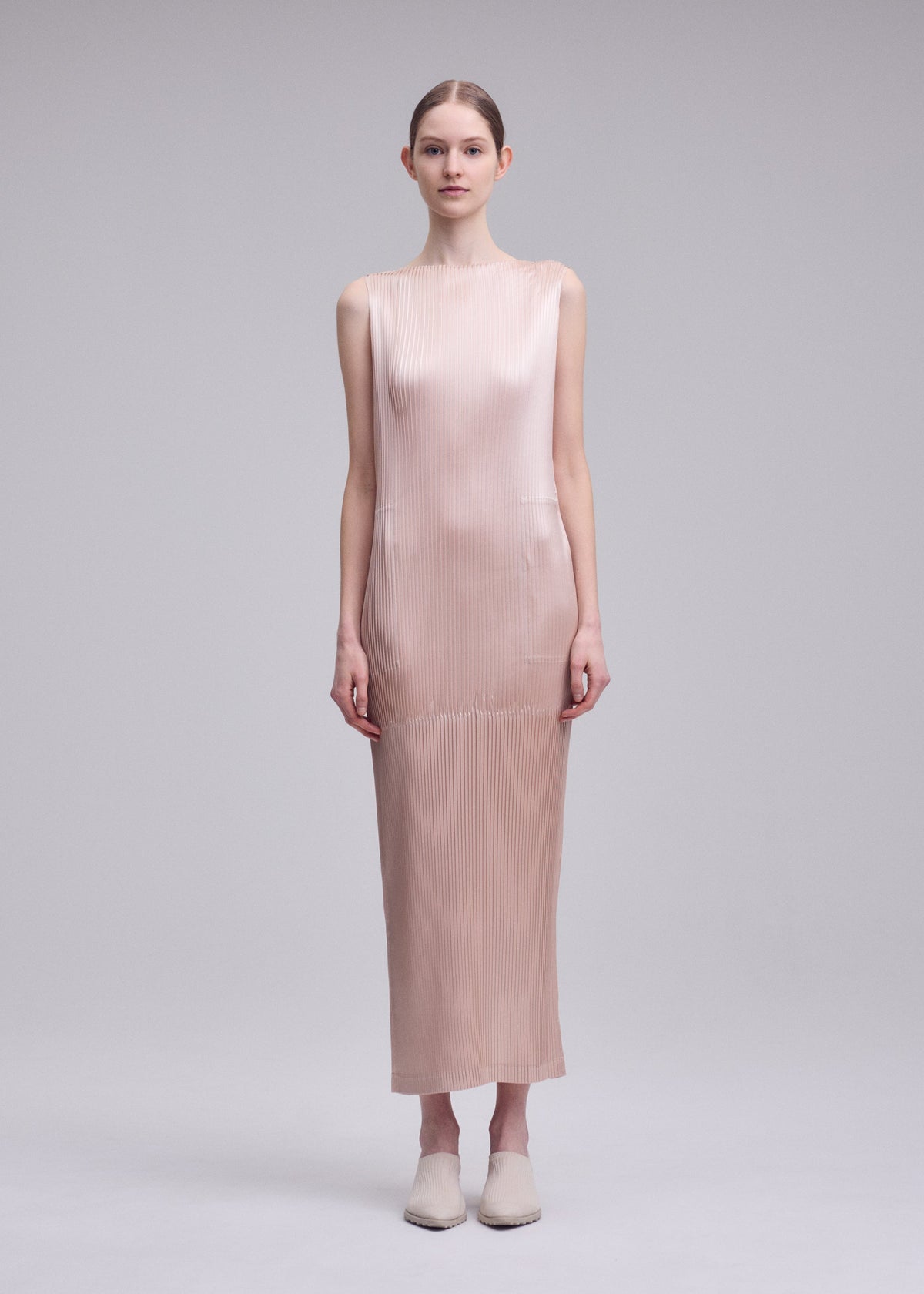 A model wears the ISSEY MIYAKE GLOSSED PANELS PLEATS glossed-panels-pleats-dress-black.