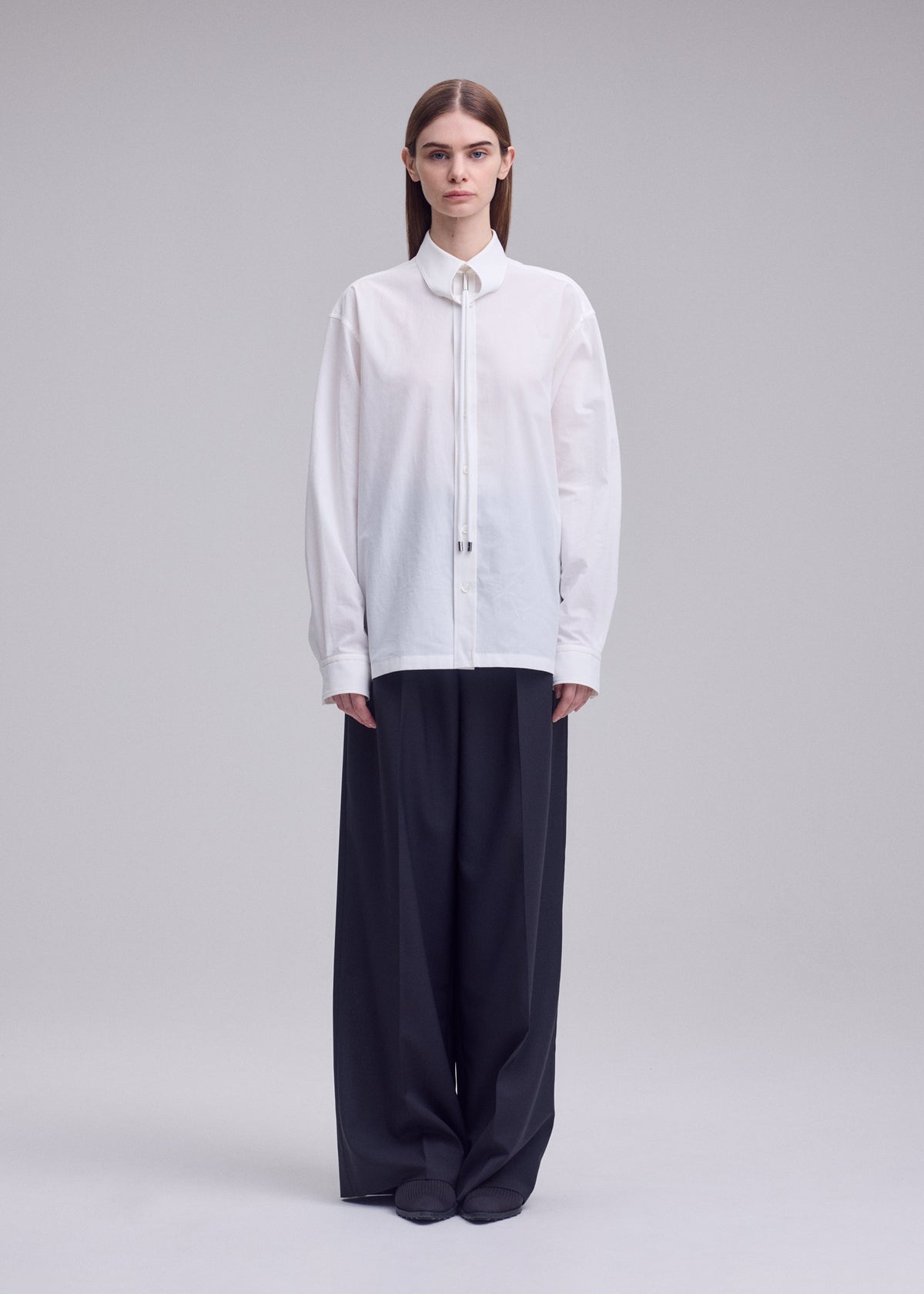 A model wears the ISSEY MIYAKE MONSIEUR SHIRT monsieur-shirt-shirt-white.