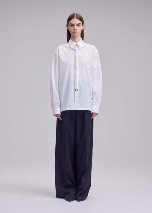 A model wears the ISSEY MIYAKE MONSIEUR SHIRT monsieur-shirt-shirt-white.