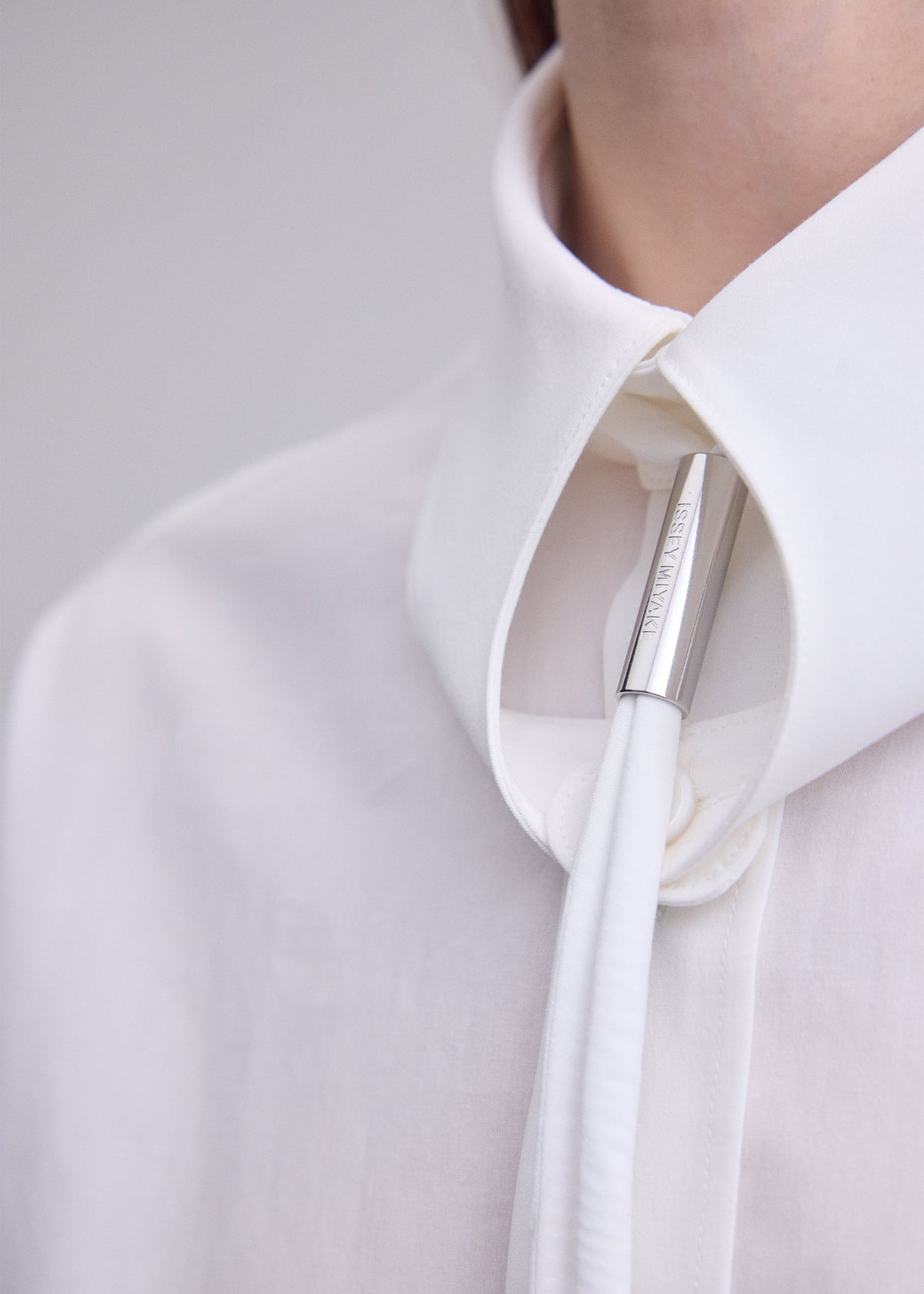 A model wears the ISSEY MIYAKE MONSIEUR SHIRT monsieur-shirt-shirt-white.