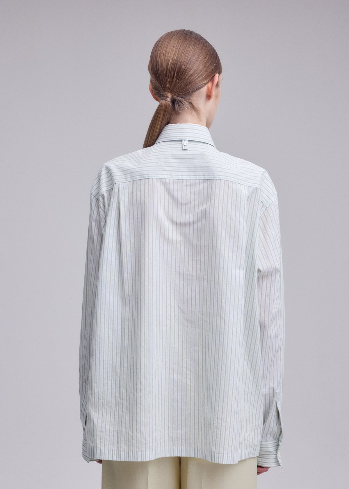 A model wears the ISSEY MIYAKE MONSIEUR SHIRT(DOBBY STRIPE) monsieur-shirt-dobby-stripe-shirt-white-hued.