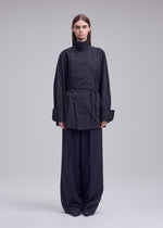 A model wears the ISSEY MIYAKE MONSIEUR SHIRT(DOBBY STRIPE) monsieur-shirt-dobby-stripe-bolo-tie-belt-shirt-black-hued.