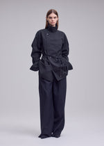 A model wears the ISSEY MIYAKE MONSIEUR SHIRT(DOBBY STRIPE) monsieur-shirt-dobby-stripe-bolo-tie-belt-shirt-white-hued.