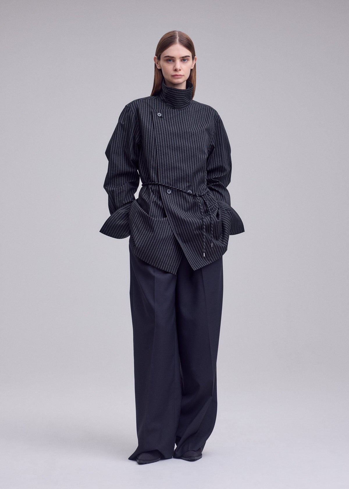 A model wears the ISSEY MIYAKE MONSIEUR SHIRT(DOBBY STRIPE) monsieur-shirt-dobby-stripe-bolo-tie-belt-shirt-black-hued.