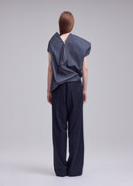 A model wears the ISSEY MIYAKE REFLECTION reflection-top-grey.