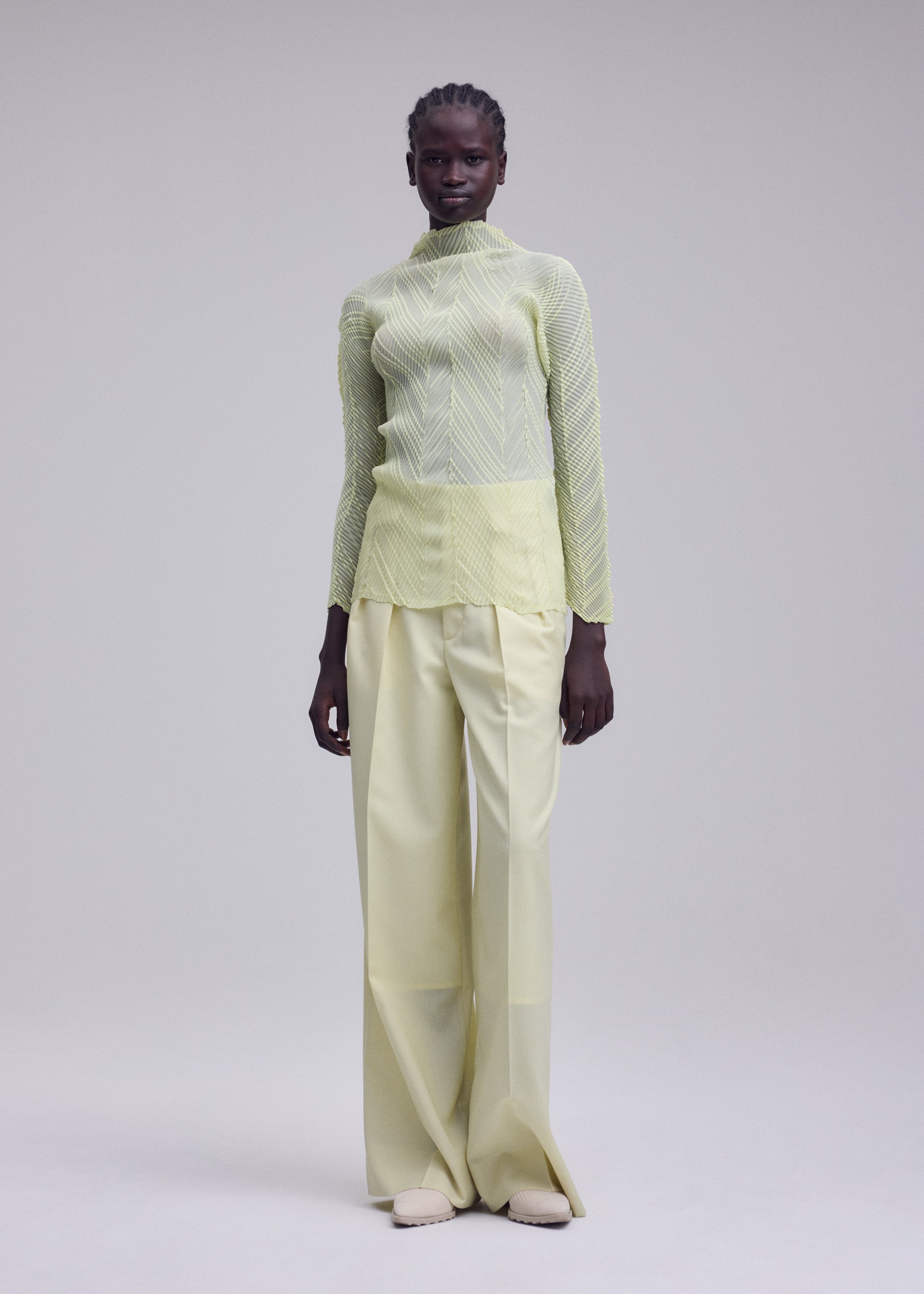 A model wears the ISSEY MIYAKE ZIGZAG PLEATS zigzag-pleats-long-sleeved-top-light-blue.
