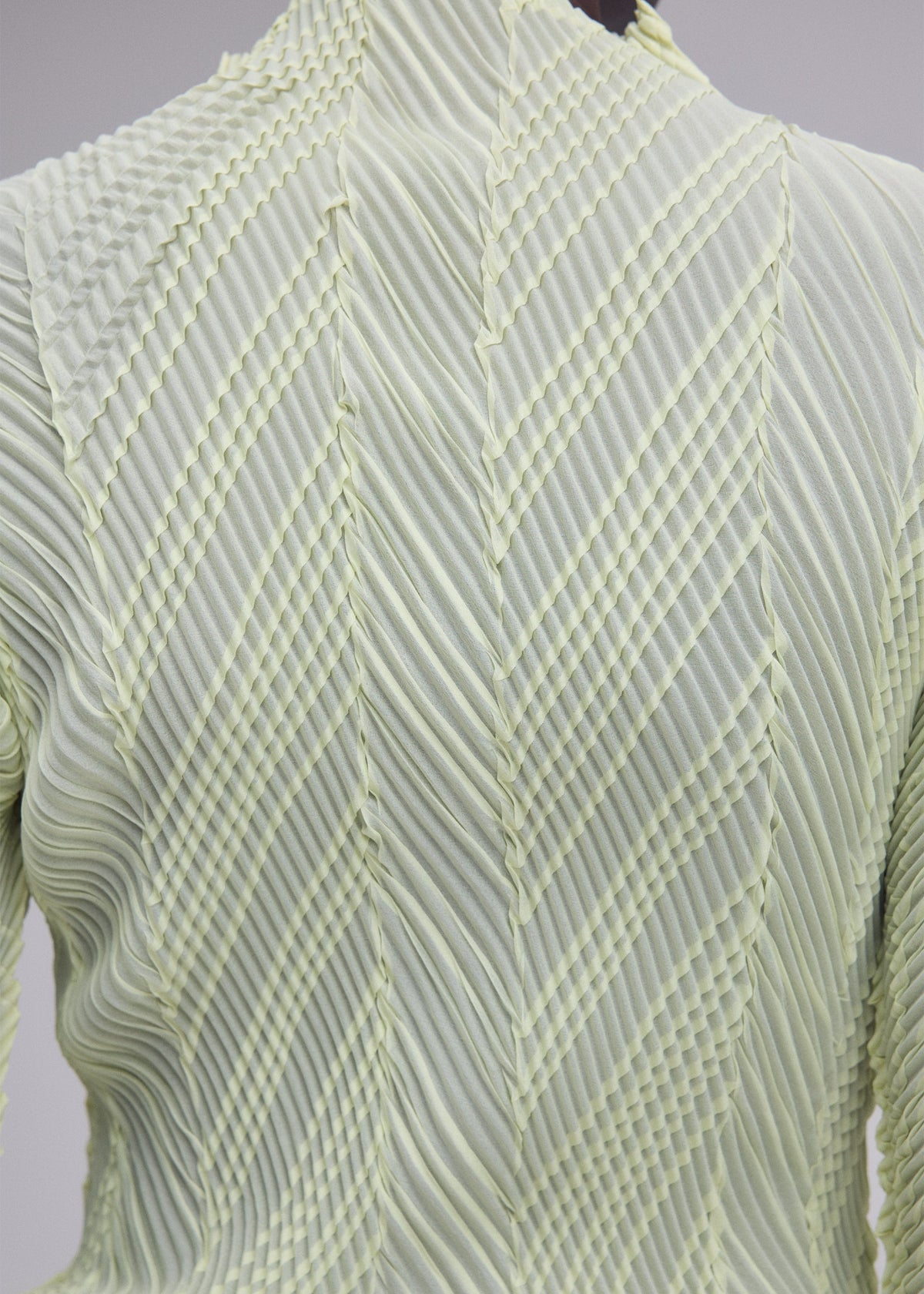 A model wears the ISSEY MIYAKE ZIGZAG PLEATS zigzag-pleats-long-sleeved-top-light-blue.