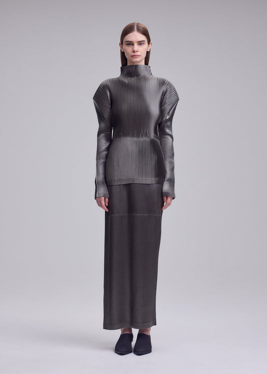 A model wears the ISSEY MIYAKE GLOSSED PANELS PLEATS glossed-panels-pleats-top-light-pink.