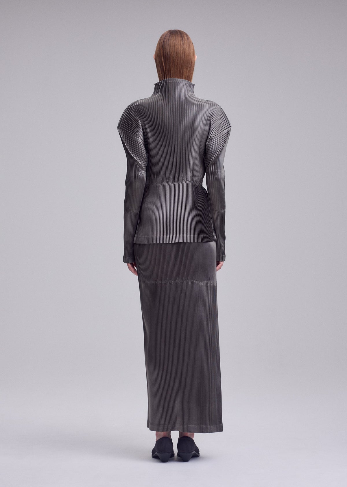 A model wears the ISSEY MIYAKE GLOSSED PANELS PLEATS glossed-panels-pleats-top-grey.