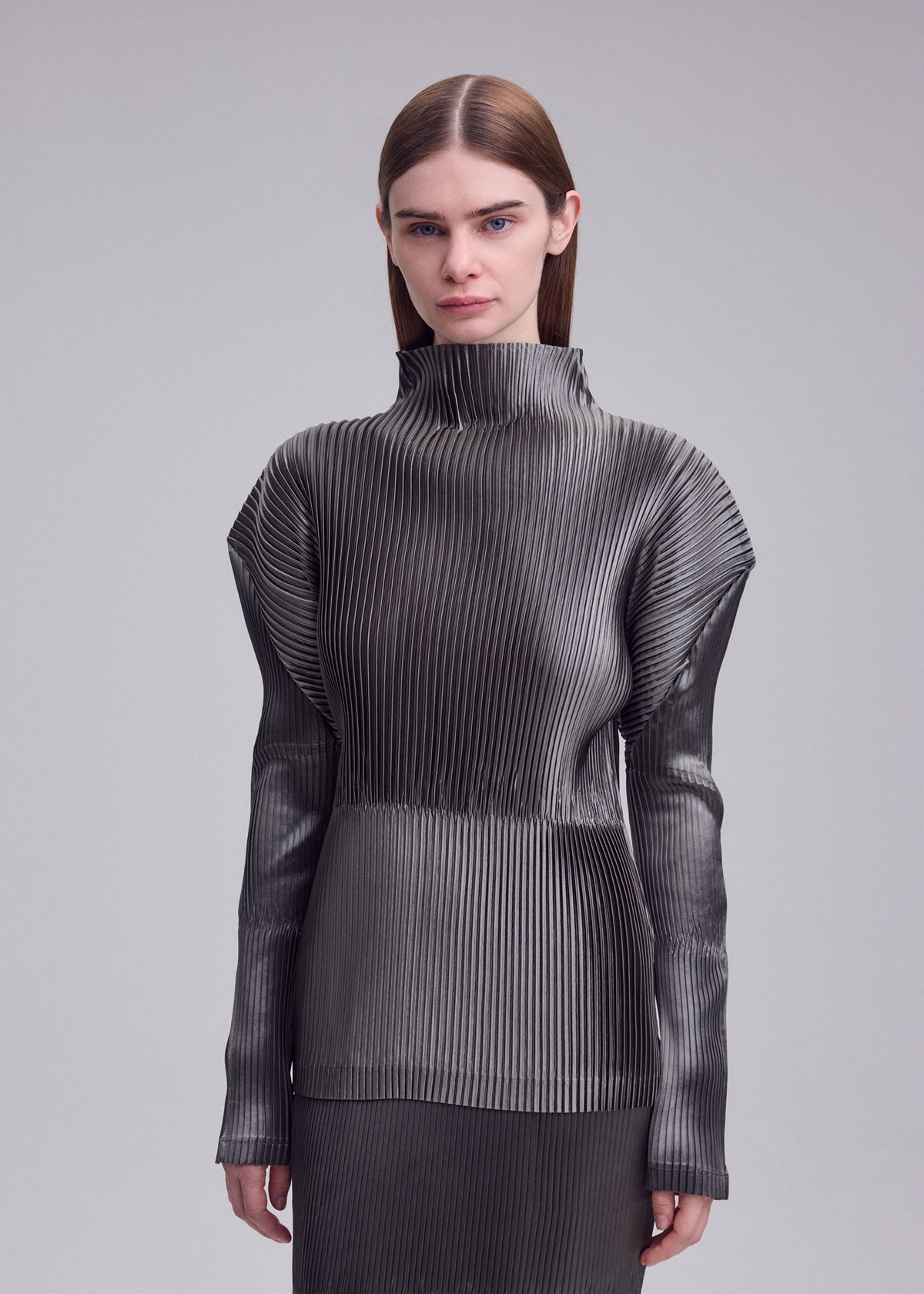 A model wears the ISSEY MIYAKE GLOSSED PANELS PLEATS glossed-panels-pleats-top-black.
