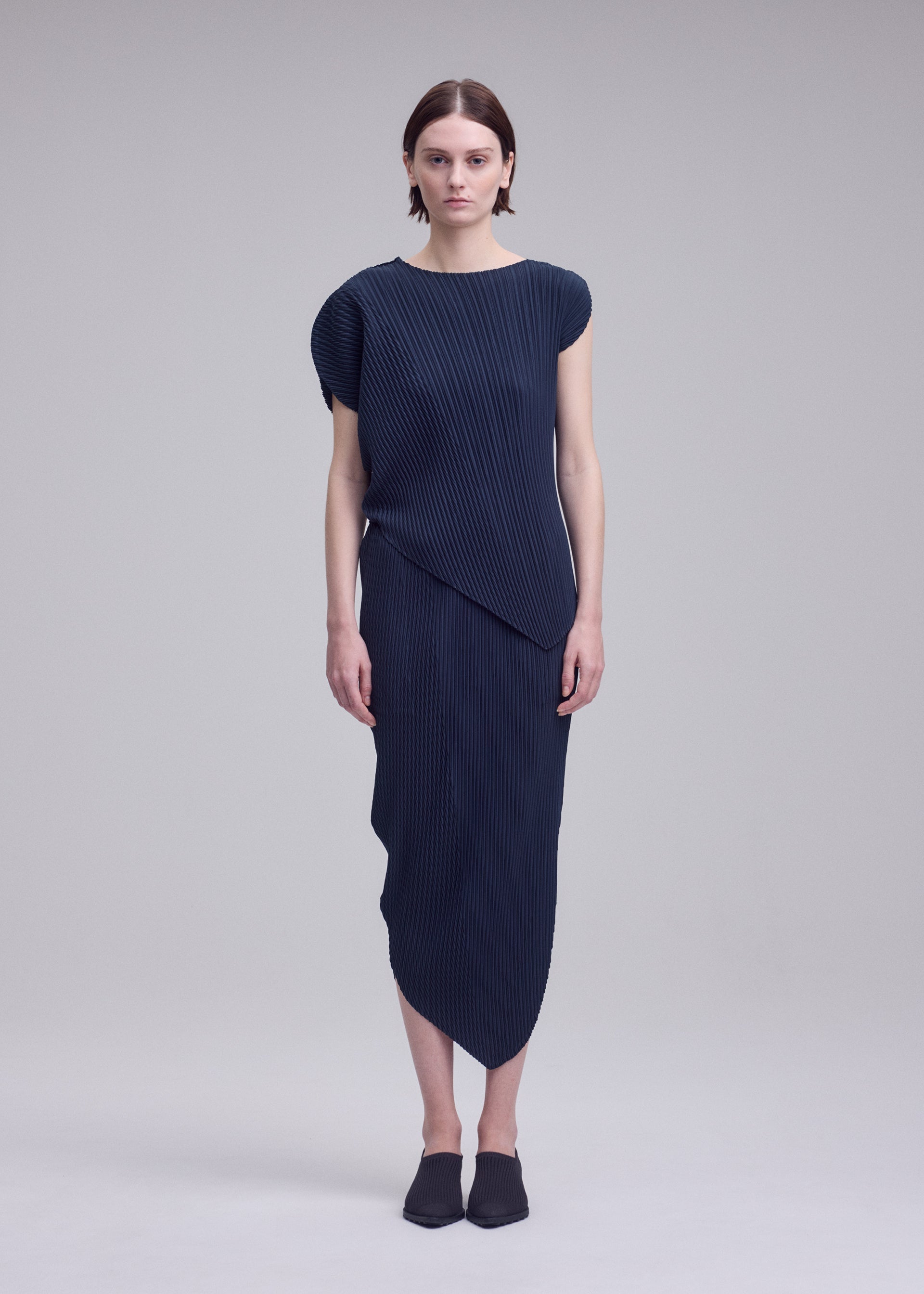 A model wears the ISSEY MIYAKE LEAF PLEATS leaf-pleats-top-dark-navy.