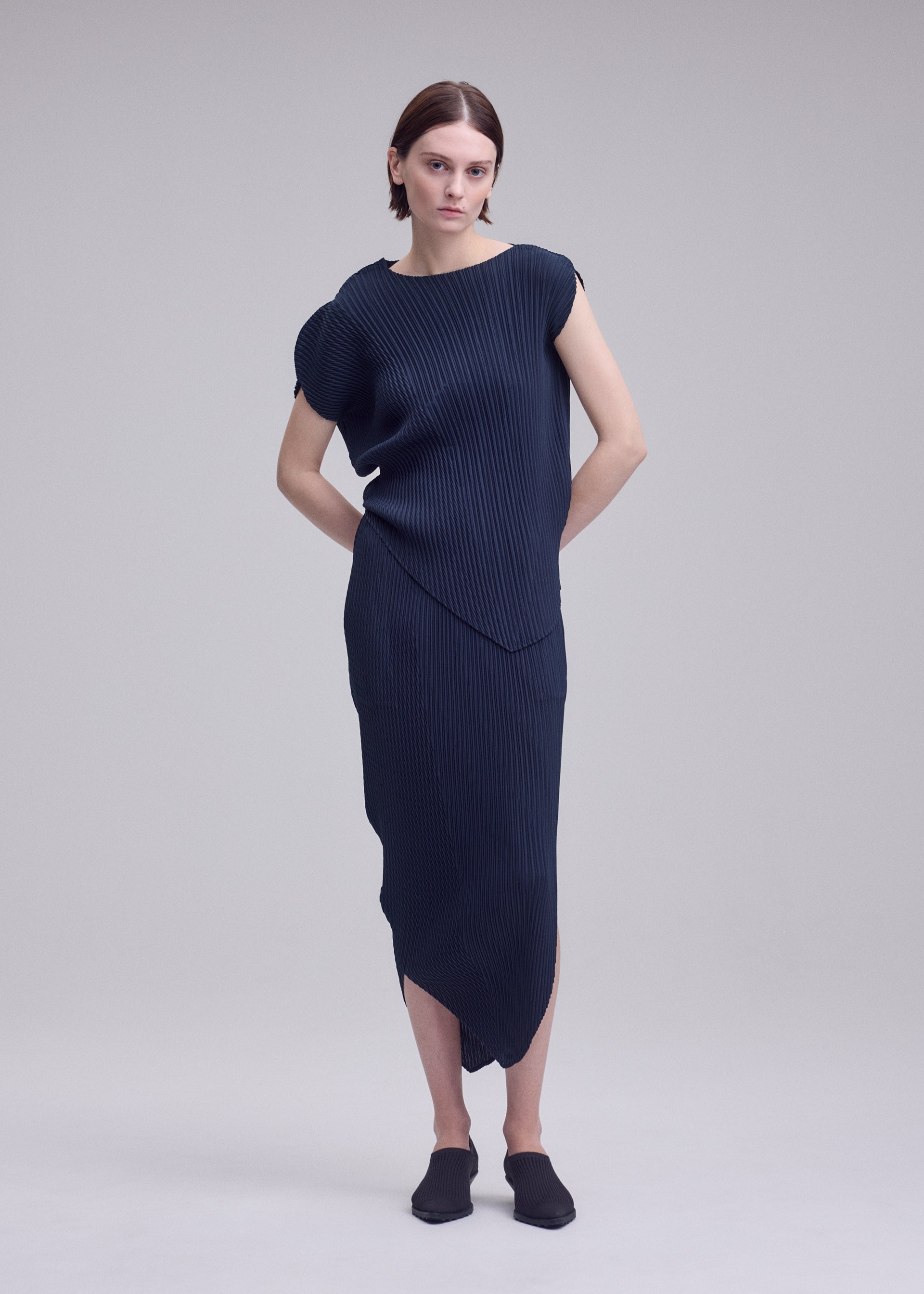 A model wears the ISSEY MIYAKE LEAF PLEATS leaf-pleats-top-dark-navy.