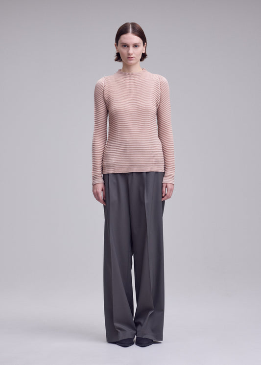 A model wears the ISSEY MIYAKE SUEDE LIKE PLEATS suede-like-pleats-long-sleeved-top-light-pink.