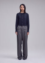 A model wears the ISSEY MIYAKE SUEDE LIKE PLEATS suede-like-pleats-round-neck-cardigan-light-pink.