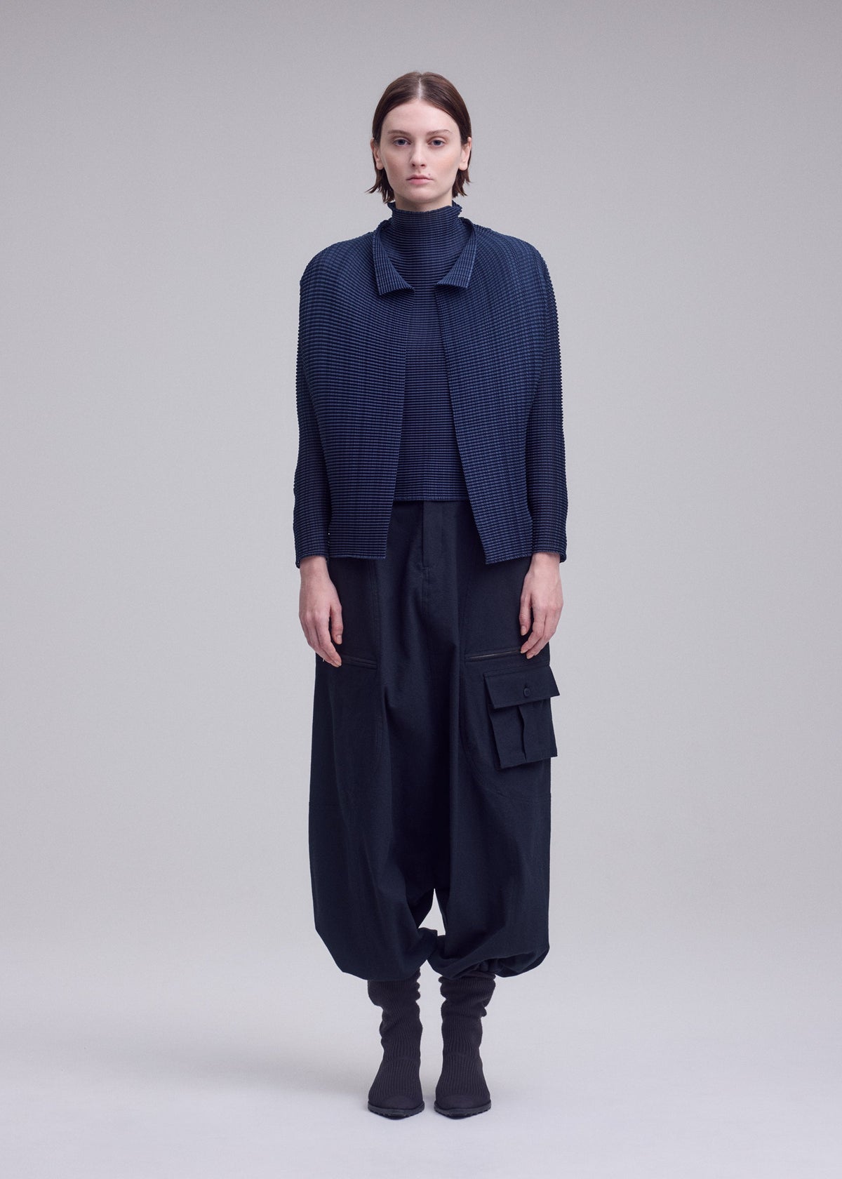 A model wears the ISSEY MIYAKE WOOLY PLEATS-68 cardigan.