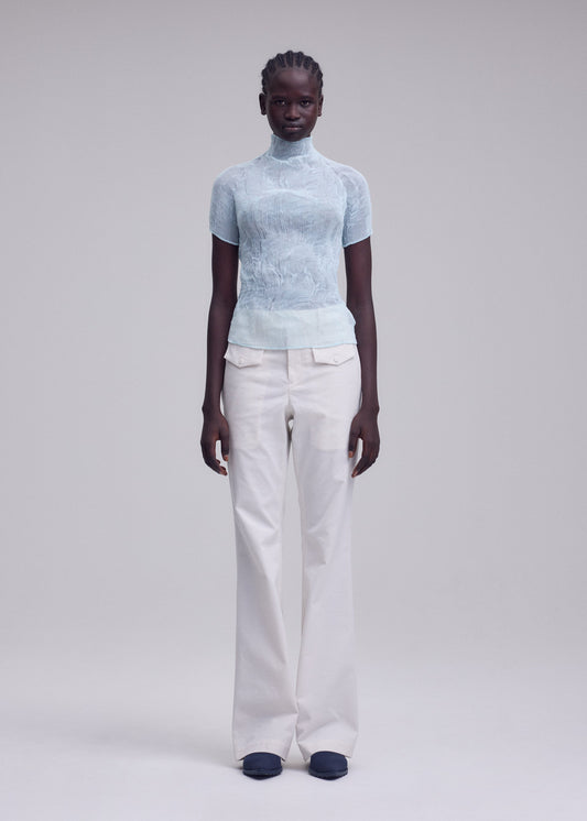 A model wears the ISSEY MIYAKE CHIFFON TWIST 1 top.