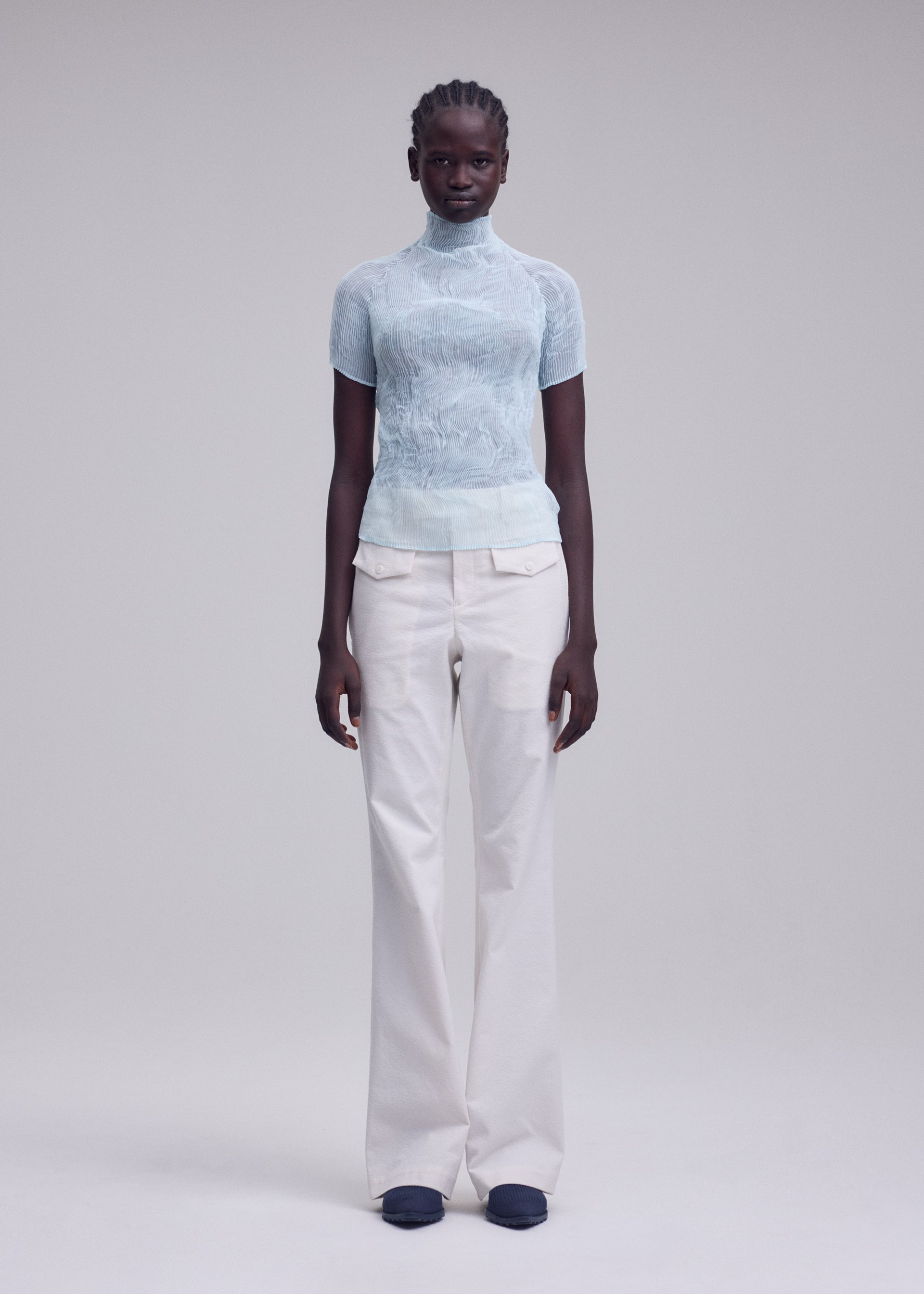 A model wears the ISSEY MIYAKE CHIFFON TWIST 1 top.