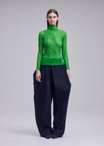 A model wears the ISSEY MIYAKE CHIFFON TWIST 1 top.