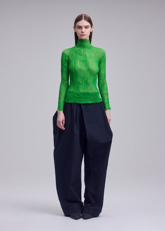 A model wears the ISSEY MIYAKE CHIFFON TWIST 1 top.