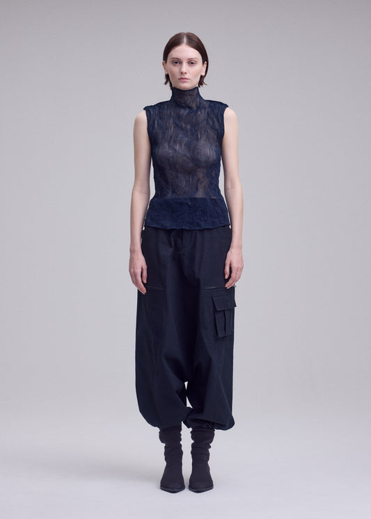 A model wears the ISSEY MIYAKE CHIFFON TWIST 1 top.