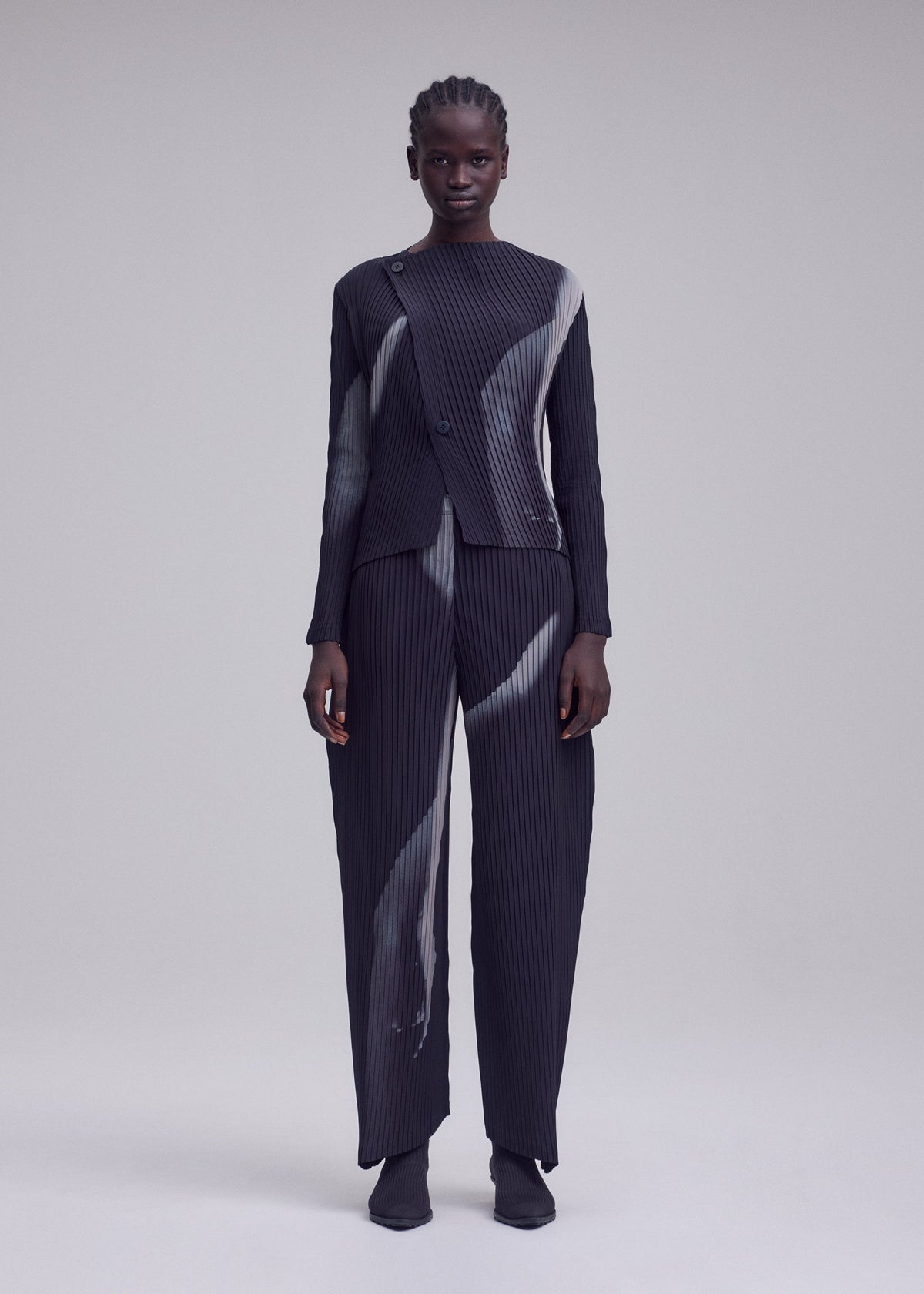 A model wears the ISSEY MIYAKE HANDS OF LOVER PLEATS hands-of-lover-pleats-cardigan-beige-hued.