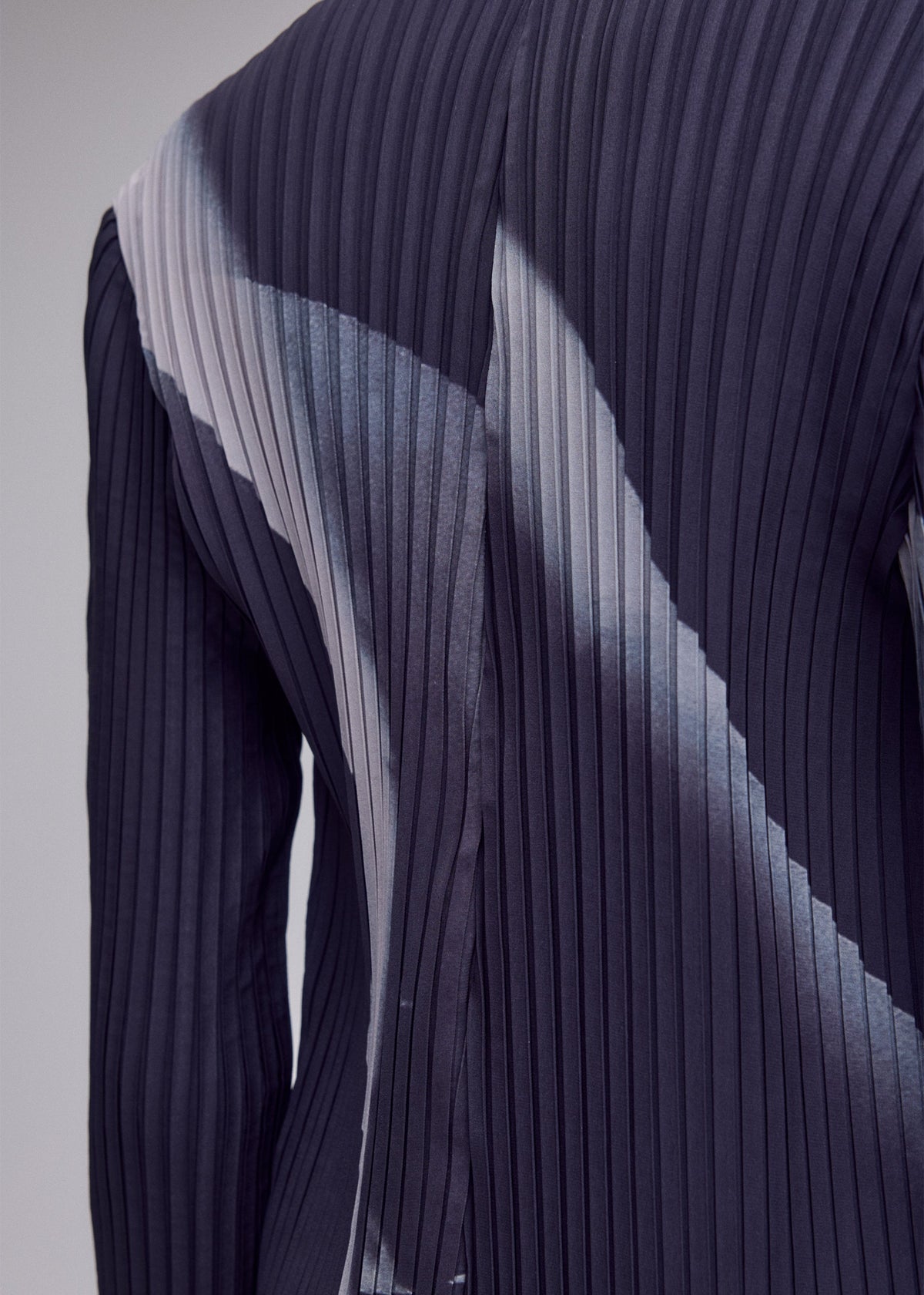 A model wears the ISSEY MIYAKE HANDS OF LOVER PLEATS hands-of-lover-pleats-cardigan-beige-hued.