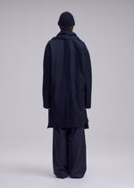 A model wears the ISSEY MIYAKE MANNER manner-coat-black.