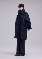 A model wears the ISSEY MIYAKE MANNER manner-coat-black.