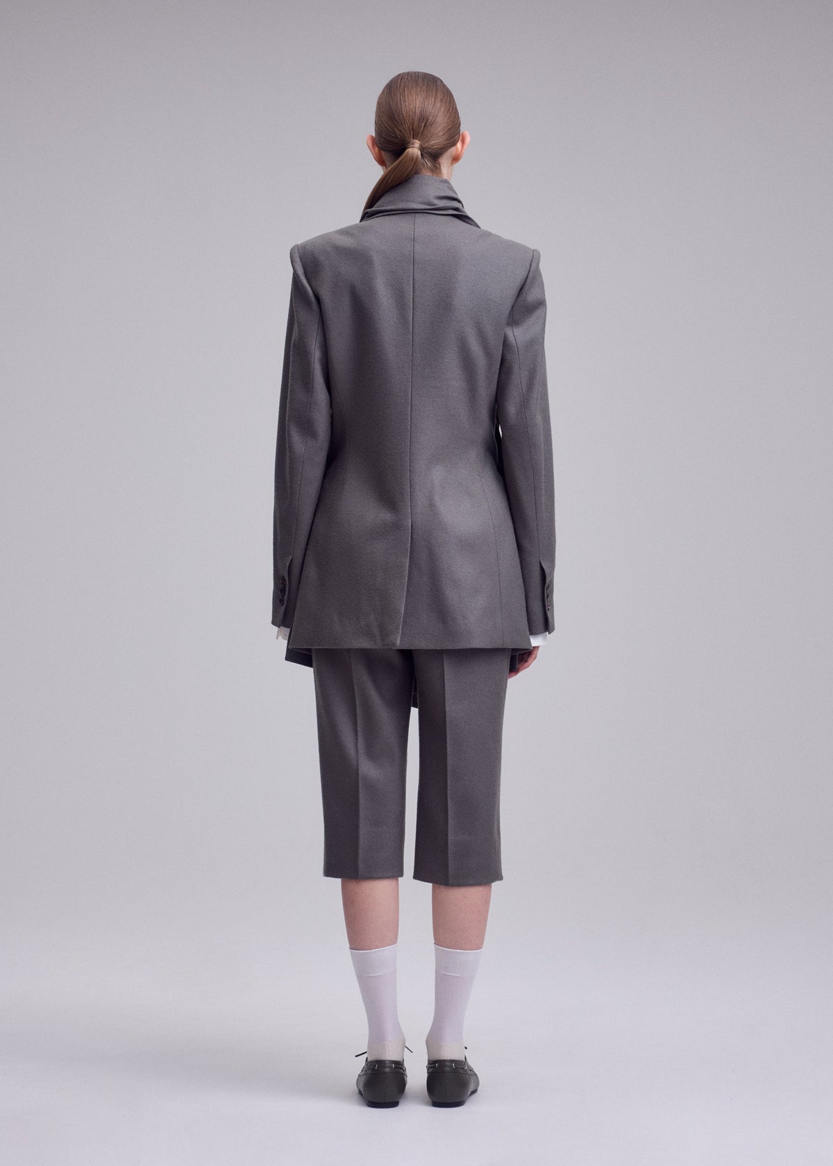 A model wears the ISSEY MIYAKE MANNER manner-jacket-black.