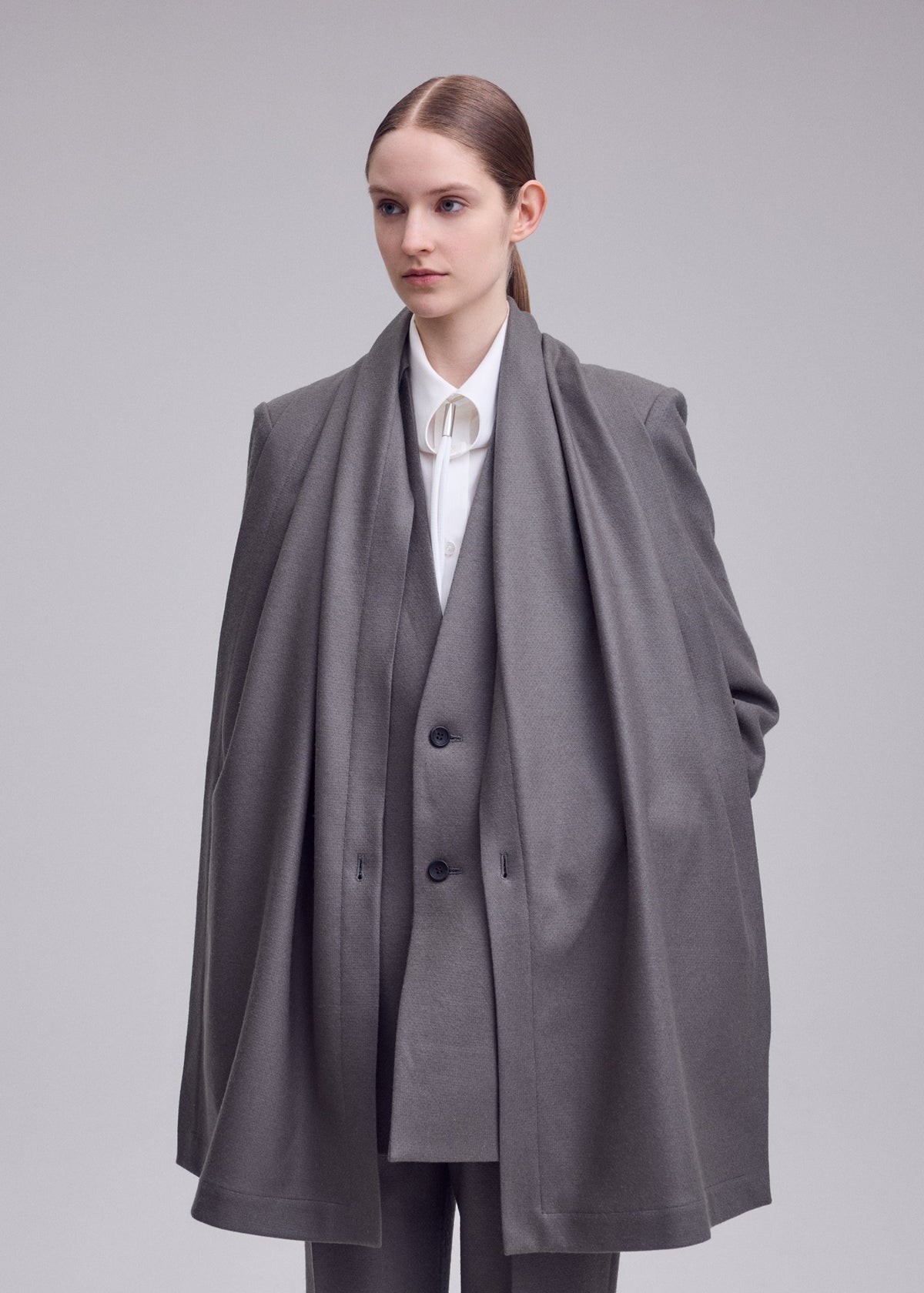 A model wears the ISSEY MIYAKE MANNER manner-jacket-grey.