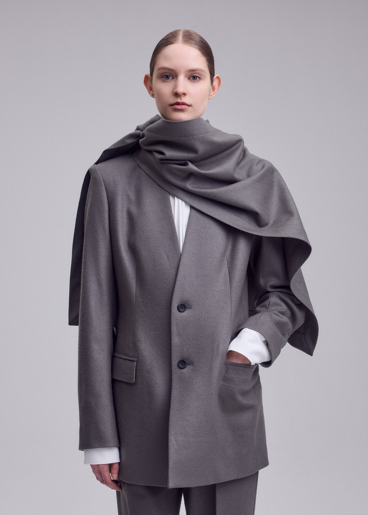 A model wears the ISSEY MIYAKE MANNER manner-jacket-grey.