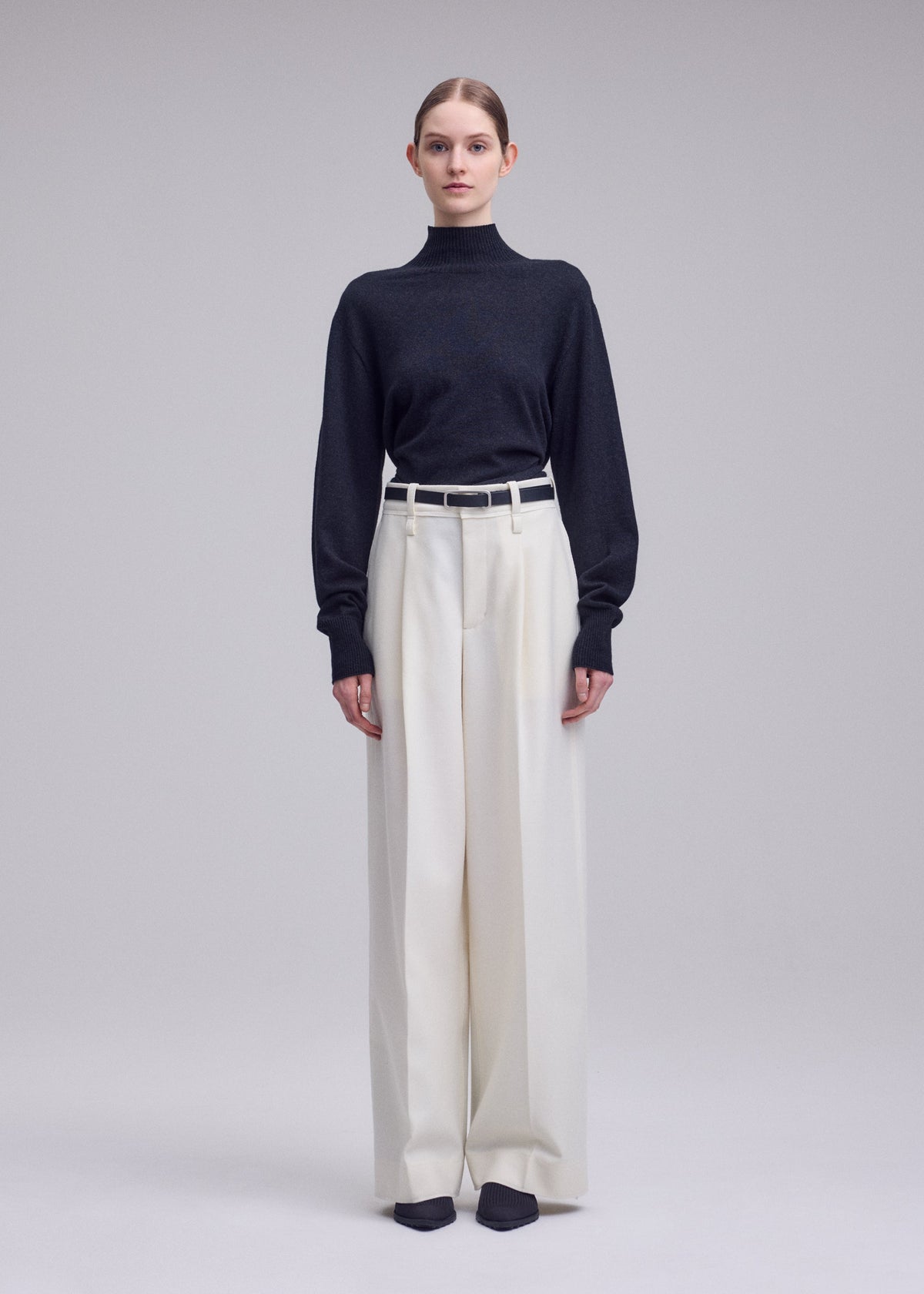 A model wears the ISSEY MIYAKE SHELL shell-trousers-grey.