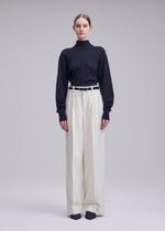 A model wears the ISSEY MIYAKE SHELL shell-trousers-grey.