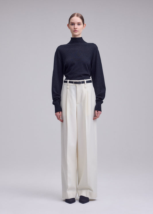 A model wears the ISSEY MIYAKE SHELL shell-trousers-grey.