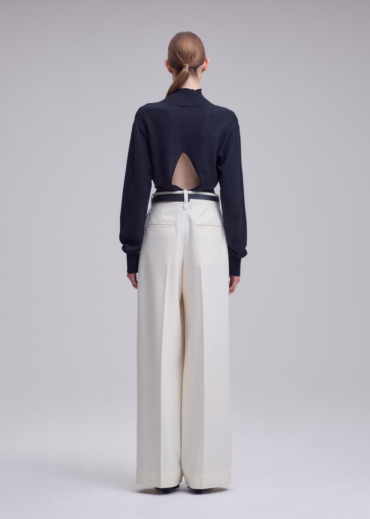 A model wears the ISSEY MIYAKE SHELL shell-trousers-grey.