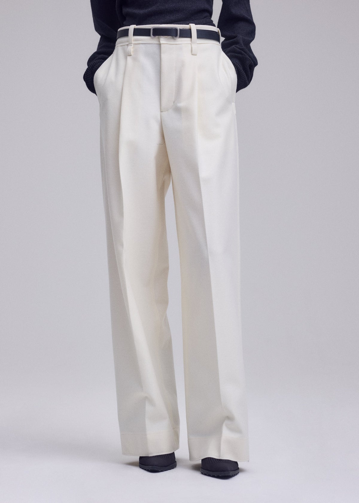 A model wears the ISSEY MIYAKE SHELL shell-trousers-grey.