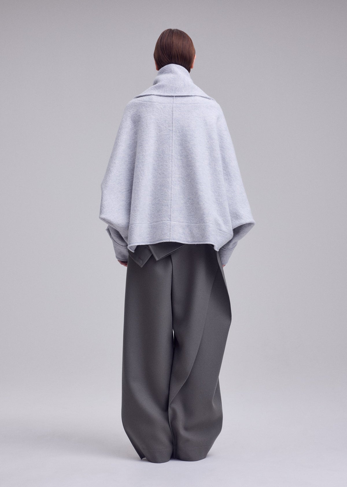 A model wears the ISSEY MIYAKE WOOLEN GRANITE woolen-granite-coat-beige.