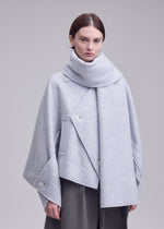 A model wears the ISSEY MIYAKE WOOLEN GRANITE woolen-granite-coat-beige.